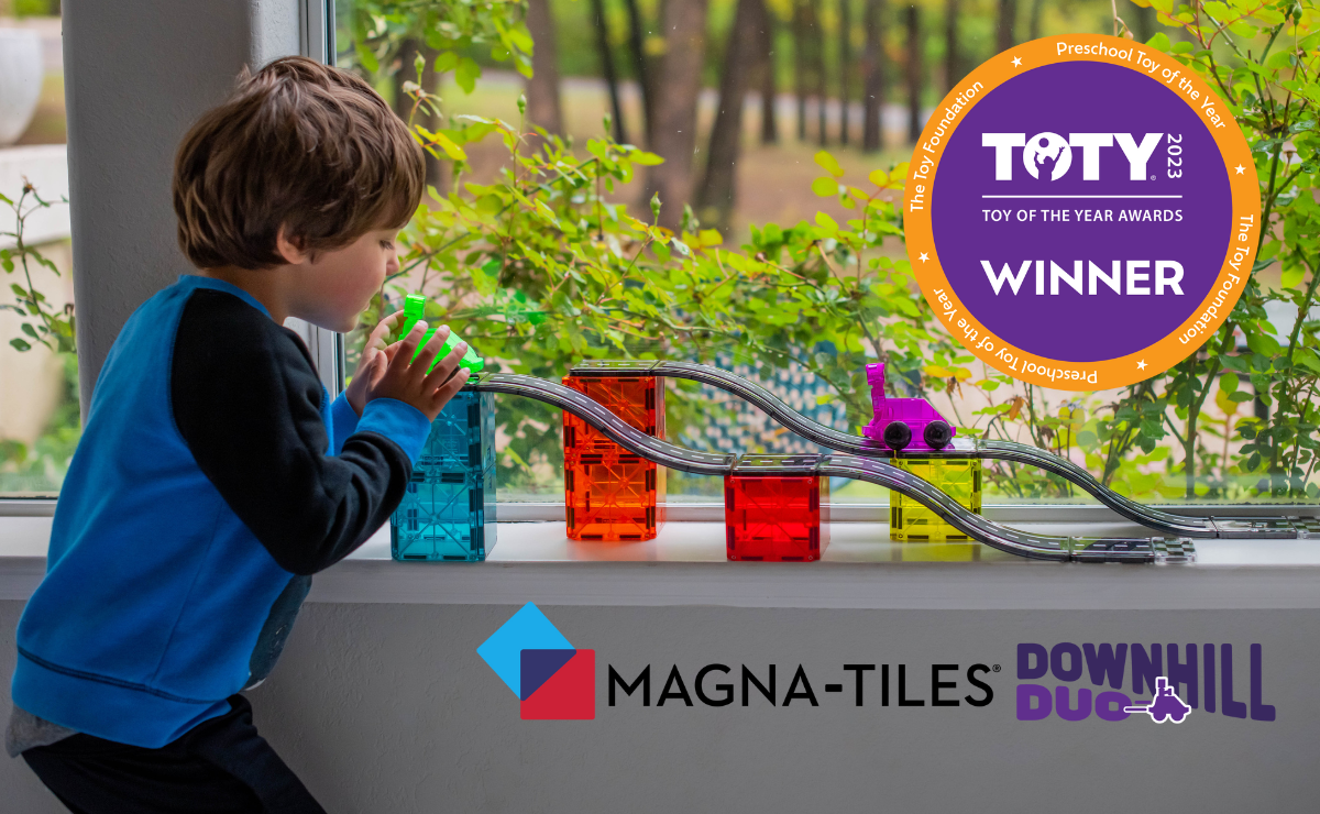 Child playing with MAGNA-TILES Downhill Duo track and colorful magnetic blocks with toy car, TOTY 2023 Winner badge visible