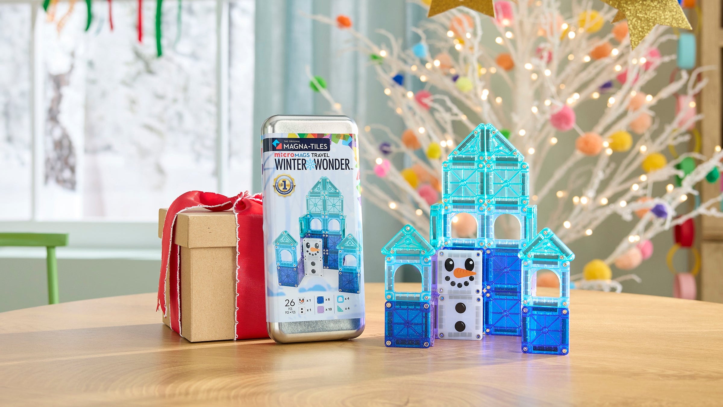 Toy building blocks with packaging on a table in a festive room with Christmas decorations.