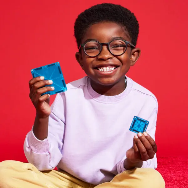 Child holding a microMAG and a classic tile