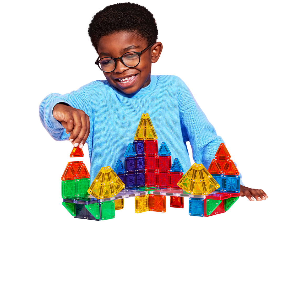 young boy playing with magnatiles set.